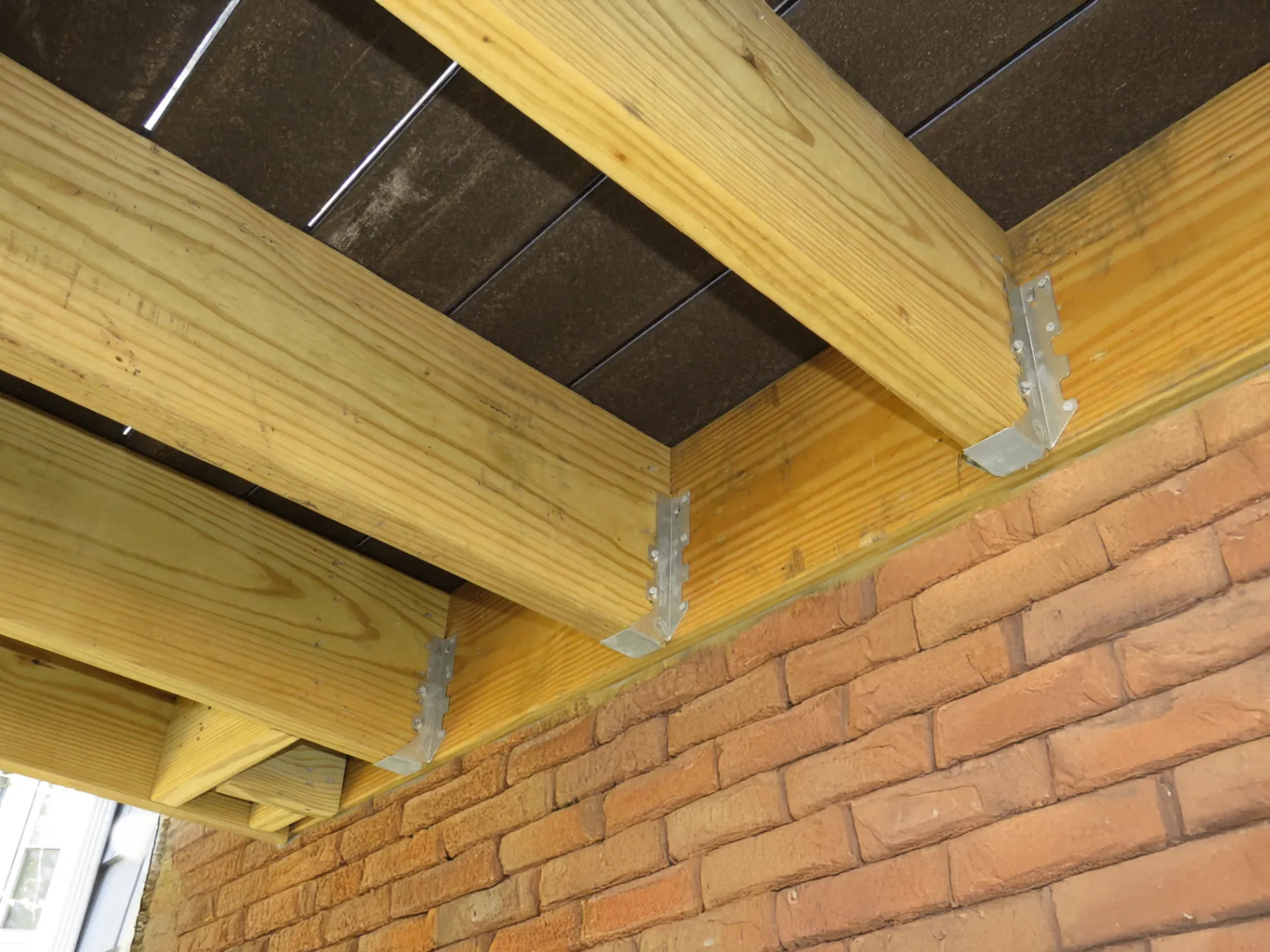 Close-up of joist hangers connecting deck framing